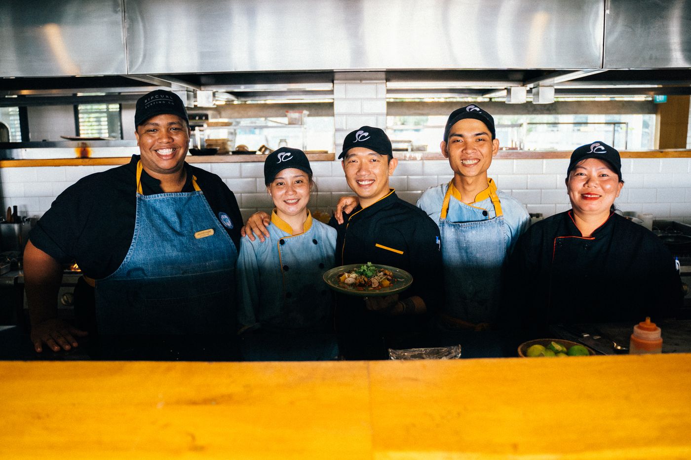 Equipo de cocina sonriendo con un plato listo