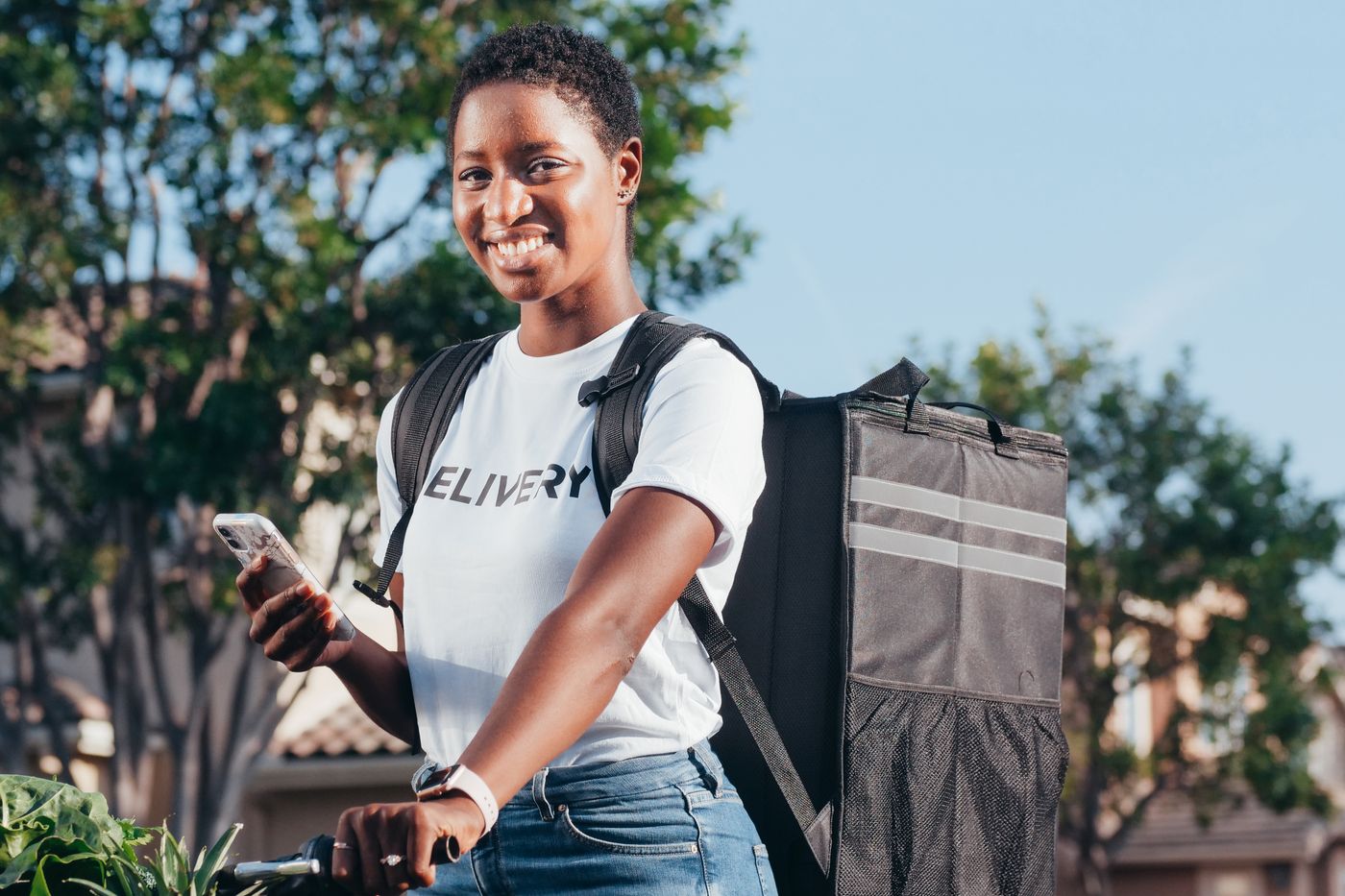 Repartidora sonriendo con la mochila de delivery